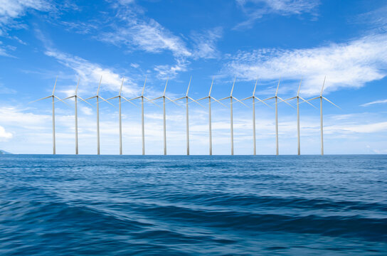Wind turbines anchored to the seabed on natural background.Offshore wind concept.