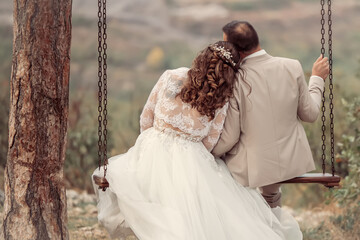 Wedding emwedding, wedding couple, romantic, relationship, couple, romance, together, swing, love, in love, husband, groom, embracing, wedding day, autumn, joy, beautiful, bridbracing in love on swing