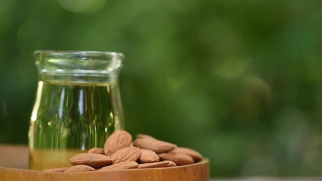 Almond seeds and oil on natural background.