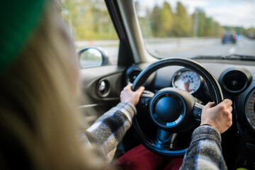 First person woman operate vehicle amid traffic on urban street or highway. Female driver city road navigation, automotive control, behind wheel, focused safe transportation, looking in windshield