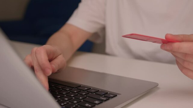 Hidden transaction amid dim lighting, Suspicious handoff between devices under low light, Scene depicting covert credit card transfer warning about online fraud risks