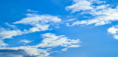 A raster image of a some cloud photographed against a blue sky. Easy relaxed cottony shape. Background quiet sky. Fiber contours after rain. Lonely free substance water. Trivial form of freedom.