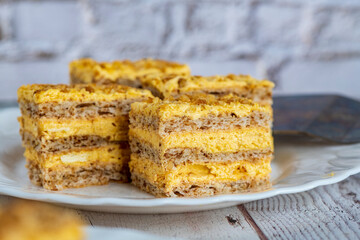 Sweet dessert cake with yellow cream and crunchy hazelnuts on top. The rich creamy filling and nutty flavor create a perfect homemade treat, ideal for pastry, bakery, or dessert themes
