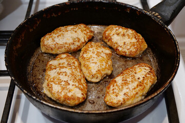 Cooking, frying meat. Five patties are cooking. Meat cutlets are fried in a pan