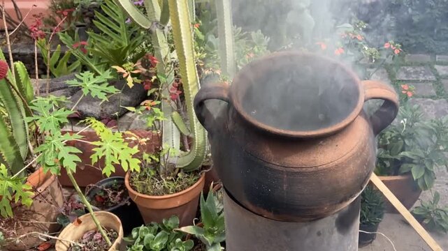 Cooking roasted chestnuts in the clay pot on fire. Fall season, homemade traditional food concept.