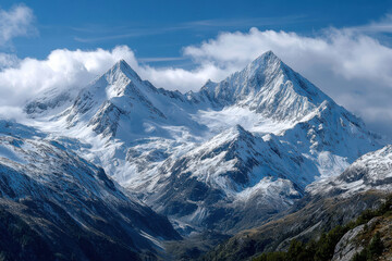 Obraz premium Snowy Mountain Peaks Under a Blue Sky with Clouds