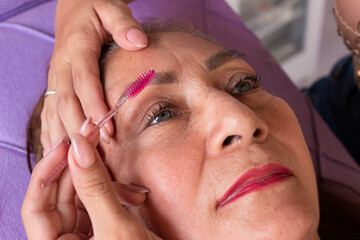 Portrait of a Hispanic woman customer receiving professional eyelash services inside a beauty salon in Neiva, Huila, Colombia. Concept of handmade