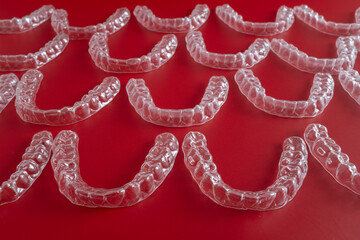 Transparent invisible dental aligners or braces aplicable for an orthodontic dental treatment. Invisible dental teeth brackets tooth aligners on blue background. Plastic braces dentistry retainers