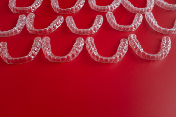 Invisible orthodontics cosmetic brackets on blue background. Tooth aligners, for beautiful smile. This invisible aligner showcases a modern approach to orthodontics and confidence in her appearance.