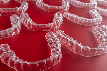 Transparent invisible dental aligners or braces aplicable for an orthodontic dental treatment. Invisible dental teeth brackets tooth aligners on blue background. Plastic braces dentistry retainers