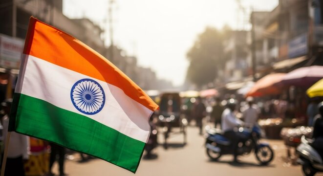 Indian flag waving as a symbol of patriotism and cultural pride during a national holiday celebration on a busy street.