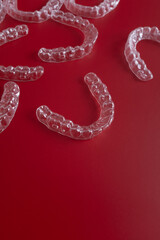 Transparent invisible dental aligners or braces aplicable for an orthodontic dental treatment. Invisible dental teeth brackets tooth aligners on blue background. Plastic braces dentistry retainers