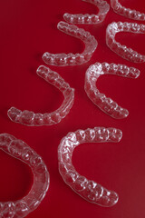 Invisible orthodontics cosmetic brackets on blue background. Tooth aligners, for beautiful smile. This invisible aligner showcases a modern approach to orthodontics and confidence in her appearance.