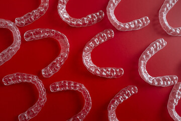 Invisible orthodontics cosmetic brackets on blue background. Tooth aligners, for beautiful smile. This invisible aligner showcases a modern approach to orthodontics and confidence in her appearance.
