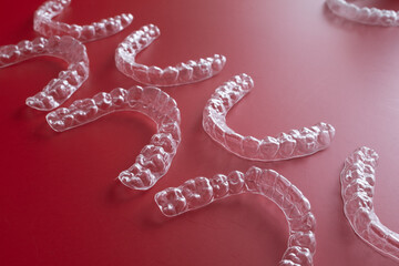 Invisible orthodontics cosmetic brackets on blue background. Tooth aligners, for beautiful smile. This invisible aligner showcases a modern approach to orthodontics and confidence in her appearance.