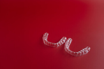 Transparent invisible dental aligners or braces aplicable for an orthodontic dental treatment. Invisible dental teeth brackets tooth aligners on blue background. Plastic braces dentistry retainers
