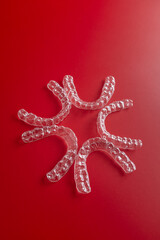 Transparent invisible dental aligners or braces aplicable for an orthodontic dental treatment. Invisible dental teeth brackets tooth aligners on blue background. Plastic braces dentistry retainers