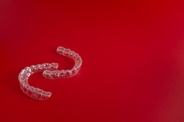 Transparent invisible dental aligners or braces aplicable for an orthodontic dental treatment. Invisible dental teeth brackets tooth aligners on blue background. Plastic braces dentistry retainers