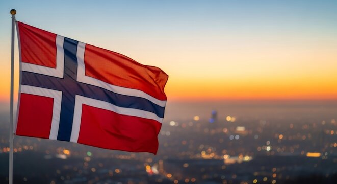 Norway national flag fluttering in front of a colorful sunset sky and blurred city lights below. Symbol of patriotism and independence in scenic landscape.