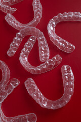 Invisible orthodontics cosmetic brackets on blue background. Tooth aligners, for beautiful smile. This invisible aligner showcases a modern approach to orthodontics and confidence in her appearance.