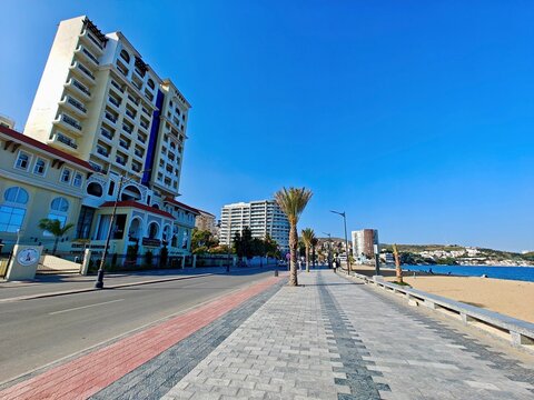 November 03. 2025. Annaba. Algeria. A sunny day on the coastal promenade of Annaba, Algeria, showcasing the Mediterranean beach, tall palm trees, and modern hotels against a clear blue sky.