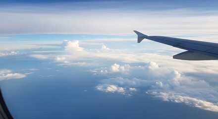 Inspirational airplane wing soaring above fluffy clouds against a vibrant blue sky, perfect for travel, adventure, and freedom concepts