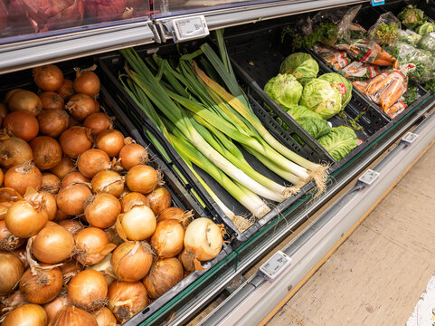 vegetable department in a retail store. Fresh onions, pipe onions and other vegetables displayed in a black plastic box. Healthy food in local market. Source of vitamines and anti oxidants.