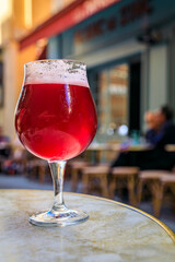 Raspberry lambic ale, old blurred buildings in background, Old Town Nice, France