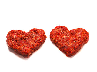 Two fresh beef burgers made in heart shape made for a romantic dinner. Love and passion concept. Premium meat. Top quality product. Creative food. White background.