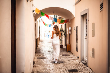 woman walking through narrow cubist streets of olh&atilde;o algarve