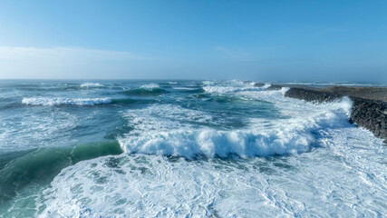 Crashing Ocean Waves Against Jetty on a Clear Blue Day