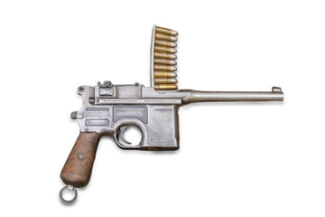 A vintage metal firearm with wooden handle, open bolt mechanism, and magazine filled with cartridges against a plain background