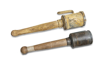 Arrangement of three historical objects on a light background wooden tool, metal container, and...