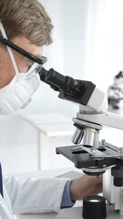 A male scientist in a protective mask looks into a microscope in a brightly lit laboratory, conducting research to develop new drugs and treatments. Medicine and science concept