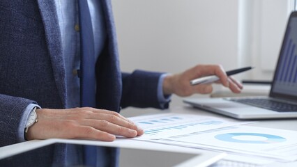 Businessman analyzing financial charts on laptop, reviewing data for strategic business planning. Business people concept
