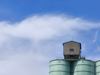 Industrial storage tanks with elevated control cabins under blue sky