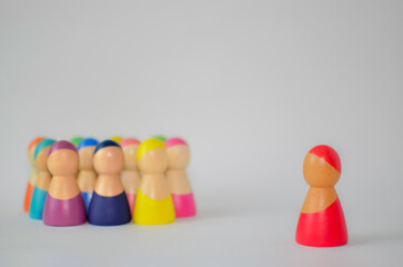 Red wooden figure standing out from a crowd
