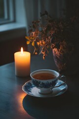 A still life photo of black tea in a simple teacup in a minimalist white-toned interior.