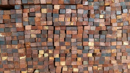 A close-up of neatly stacked wooden blocks showing natural brown, yellow, and dark wood textures. This photo is perfect for backgrounds, construction concepts, timber industry promotions, or interior 