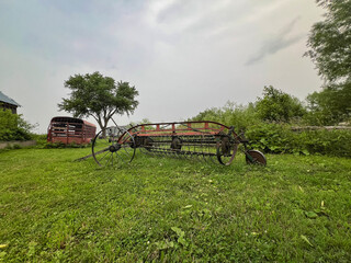 Old horse drawn hay rake in a grassy field. These are still used today by the Amish to collect hay or straw into windrows. Found in the heart of Illinois Amish Country - Arthur, Illinois.
