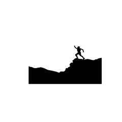 Silhouette of a person climbing a mountain peak.