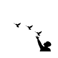 Silhouette of a person releasing birds into the sky.