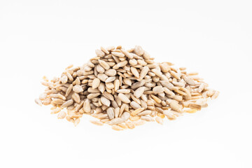 Pile of hulled sunflower seeds on a white background - Helianthus annuus