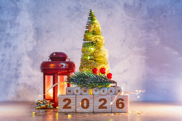 Bright festive still life celebrating New Year 2026 with glowing Christmas tree, red lantern and wooden cubes showing the year. Concept holiday decorations and cozy atmosphere winter holidays.