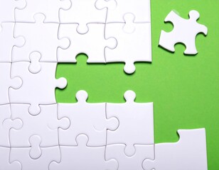 Unfinished white puzzle pieces on a vivid green background
