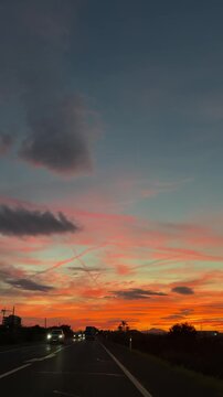 Sunset from the car in bright orange-red hues. Sunset on the road