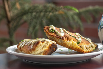 Close-up photograph of Central American empanadas on a white plate with a blurred background
