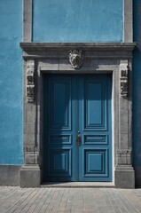 Portrait of gray door on blue wall background, beautiful architecture aesthetic concept