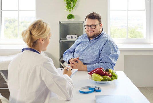 Nutritionist doctor advises fat overweight man patient on obesity diet during consultation in a healthcare medical clinic. Clear concept: healthy weight management, food and nutrition.