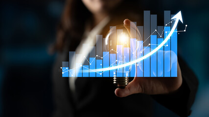 A professional holding a light bulb symbolizing innovation against a backdrop of a growing data graph, signifying business success and creative growth strategies. Scalp